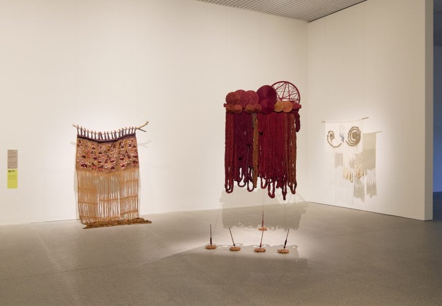 From left to right: Angélica Serech, Mani Kan num na na chire, xa oj ulew (Do not feel so superior, you are dust too), 2025; Chuwa ruxaq q’aq’ (Facing the  Flames), 2025; Aun la sombra si es constante deja huella Autor: Rubén Dario (Even the shadow, if constant, leaves a mark Author: Rubén Dario), 2025. Commissioned by the Biennale of Sydney and the Fondation Cartier pour l’art contemporain. Courtesy of the artist and La Galeria Rebelde © Angélica Serech. Installation view, 25th Biennale of Sydney, Rememory, 2026, Art Gallery of New South Wales. Photo © Art Gallery of New South Wales, Felicity Jenkins.